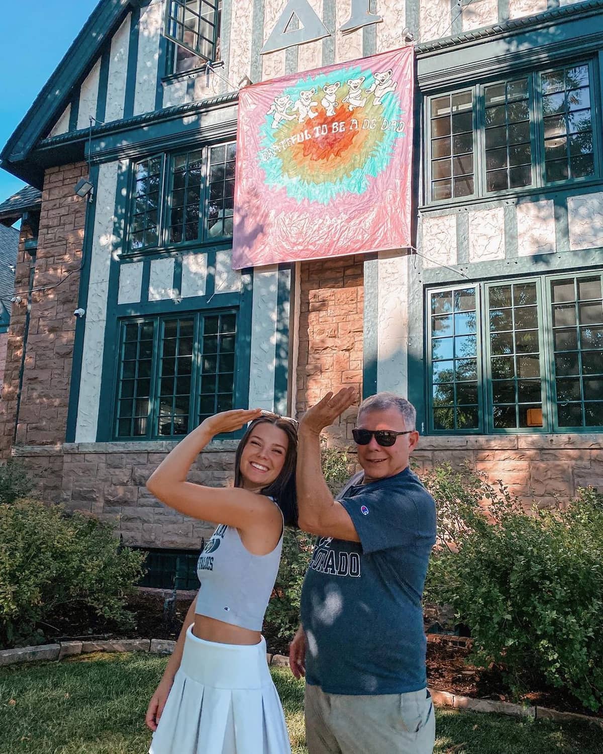Delta Gamma member posing for a photo with father in front of house
