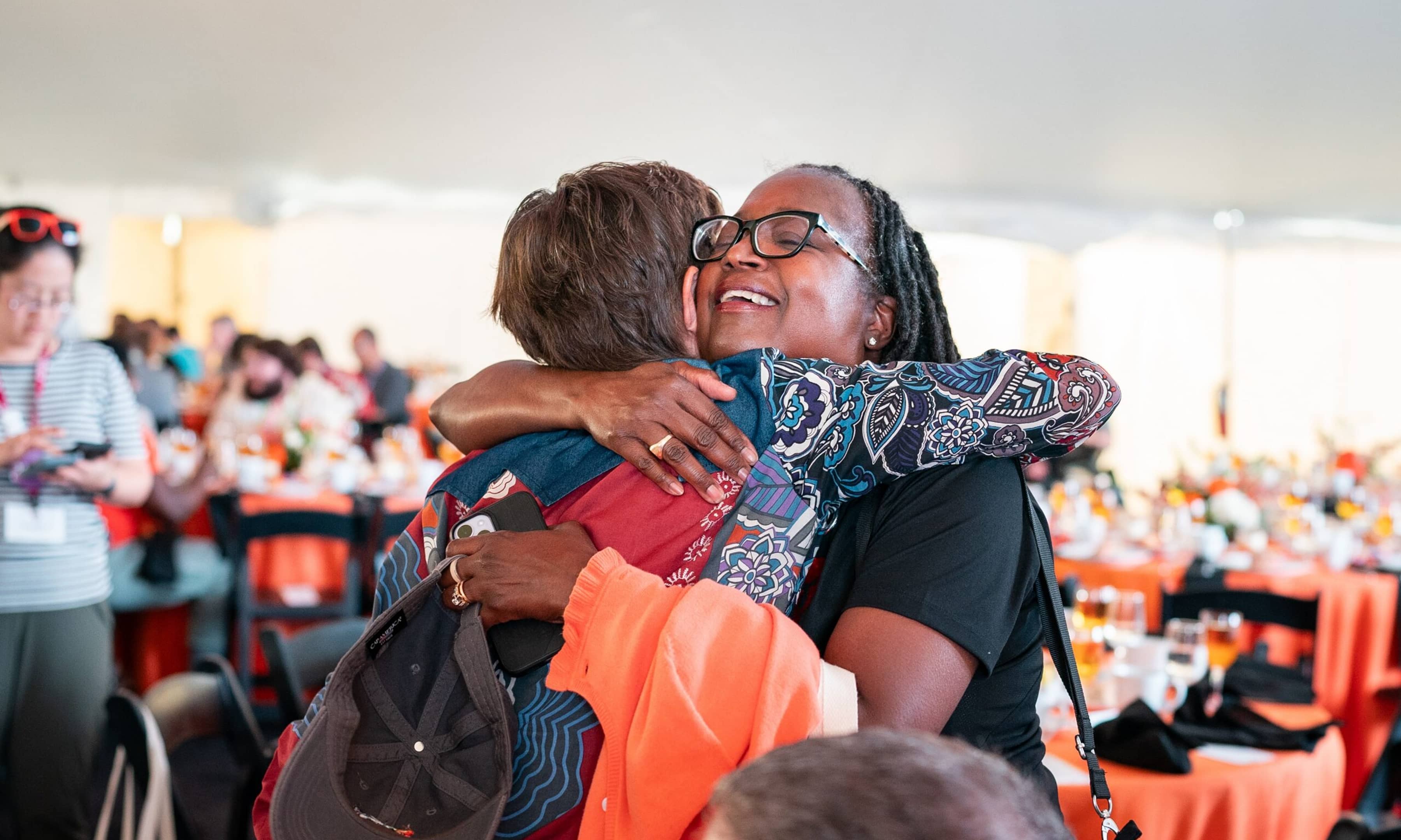 PUA Every Voice client image of two attendees hugging at event