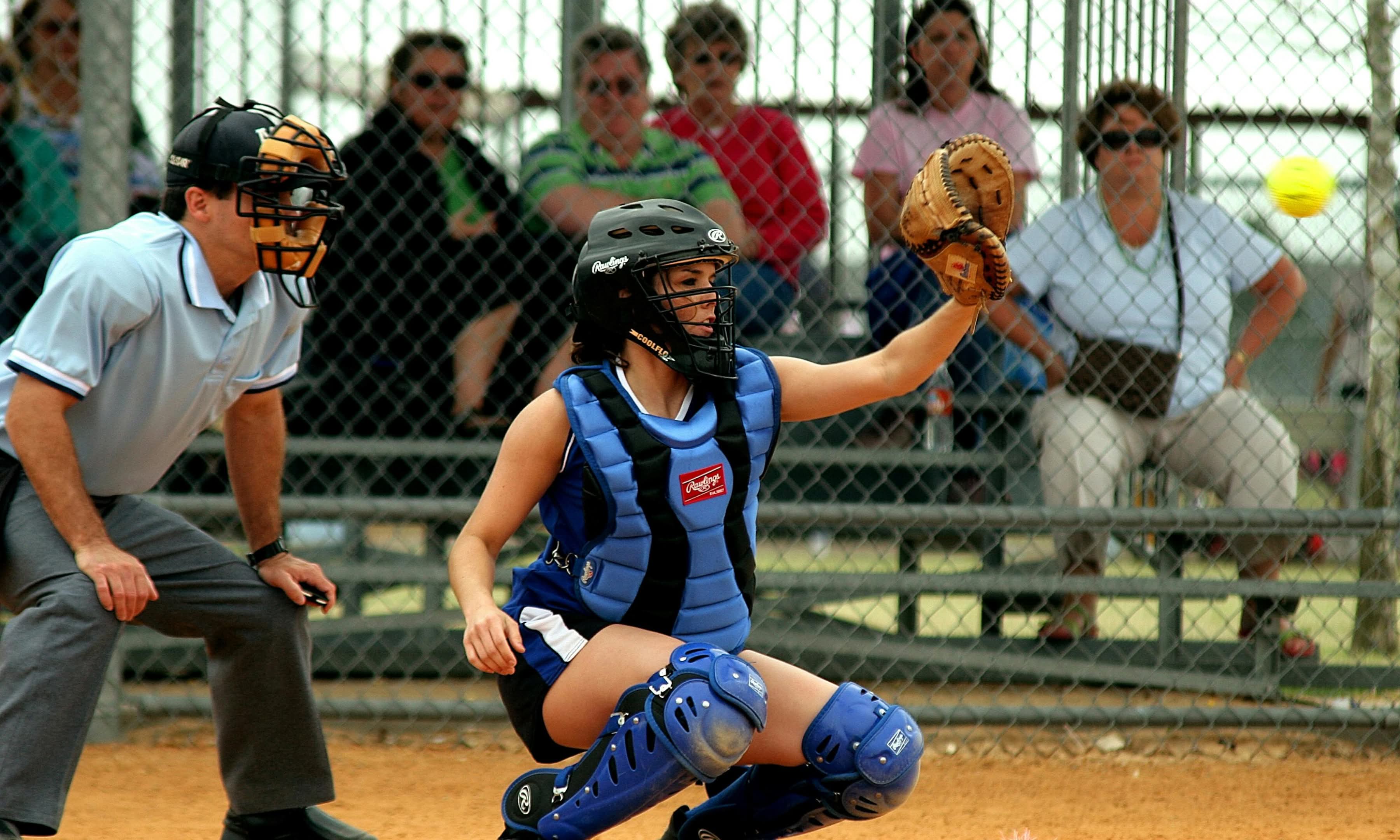 Action shot of softball catcher in front of umpire