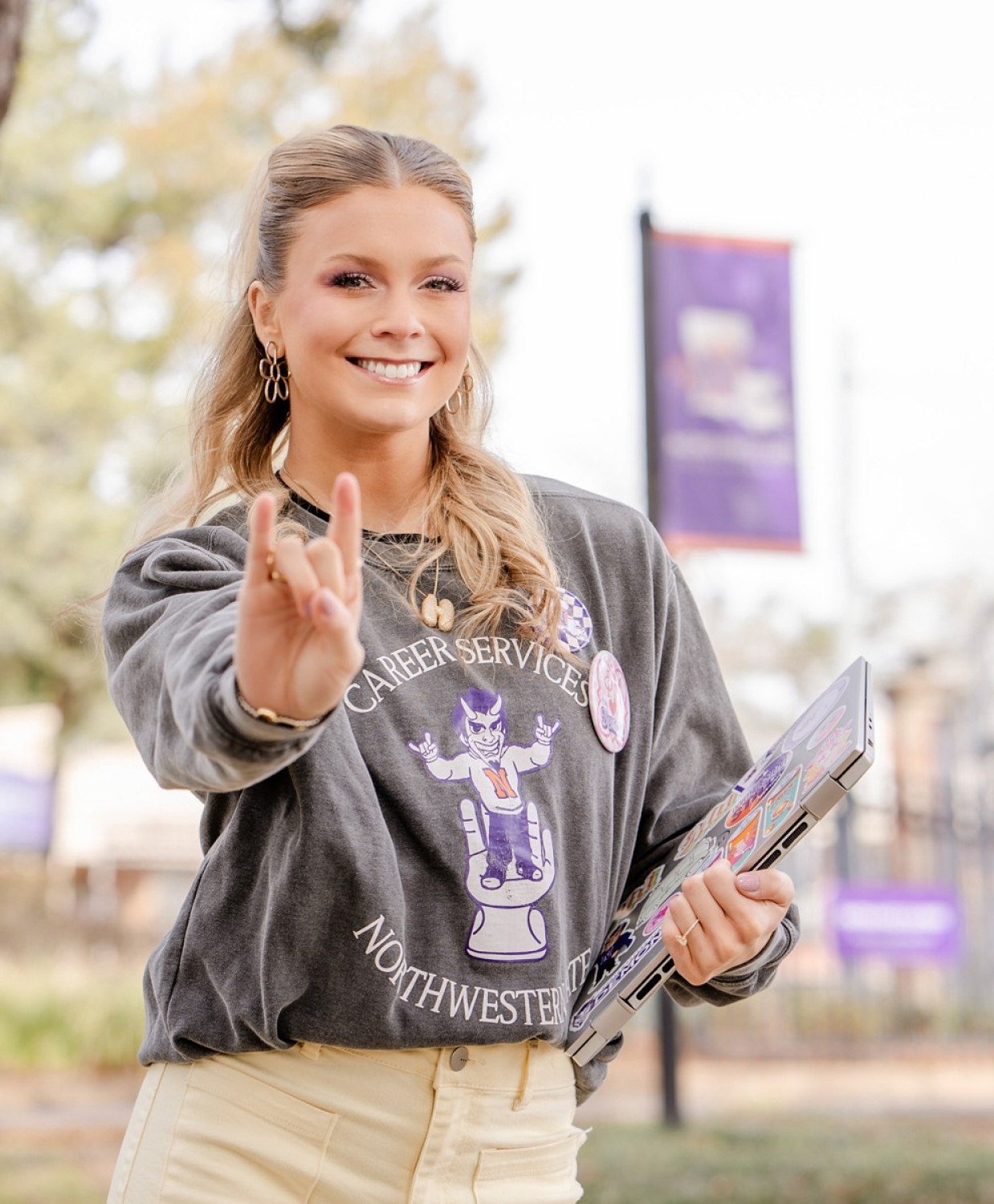 Young woman smiling outdoors, wearing a 