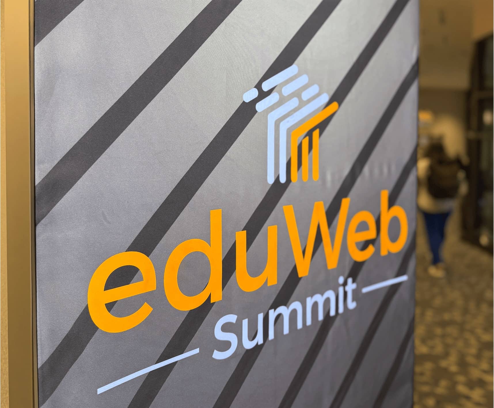 Banner for eduWEB conference with higher ed marketer walking in the background.