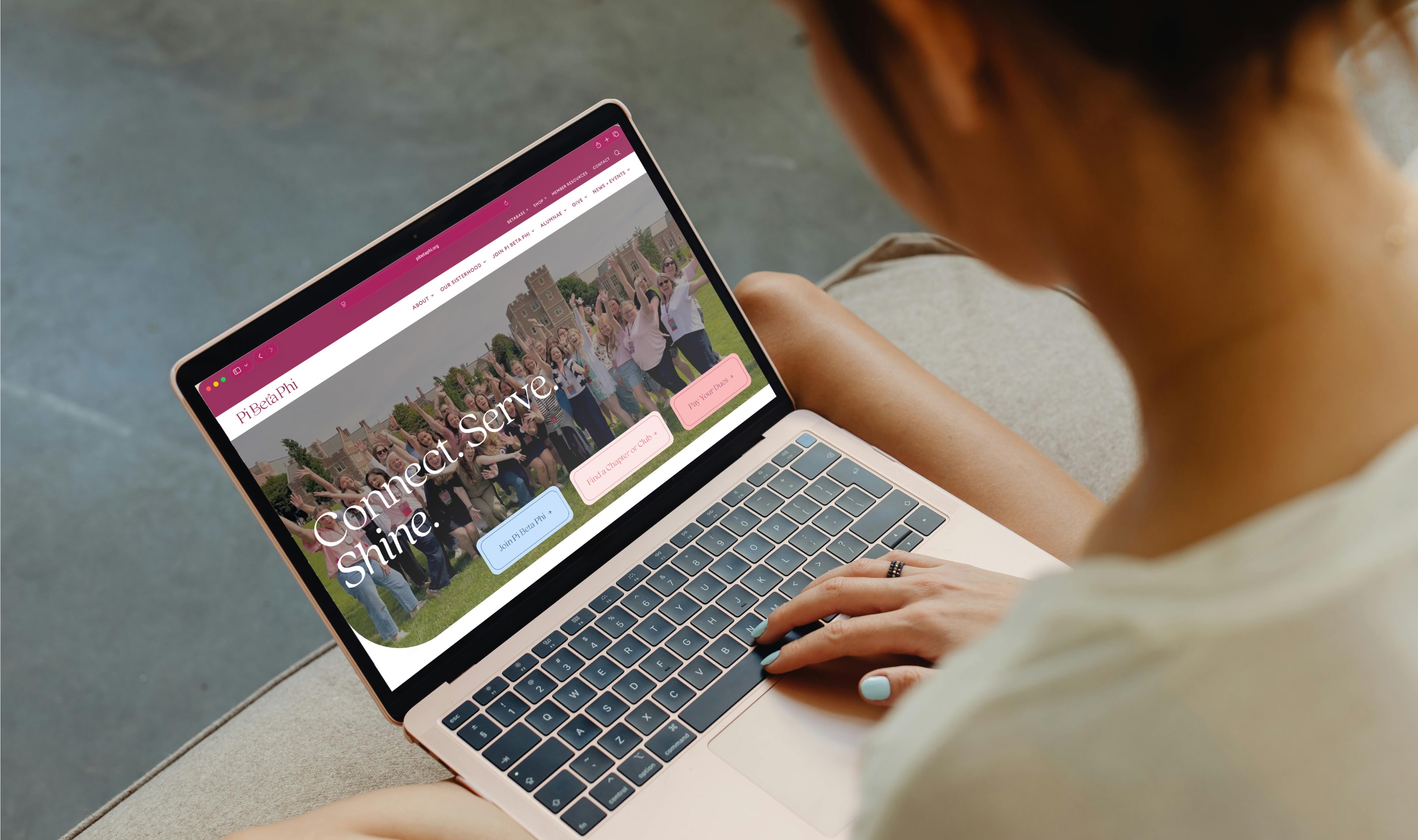Person viewing a greek organization's responsive web design on a laptop, showcasing its web development and visual identity.