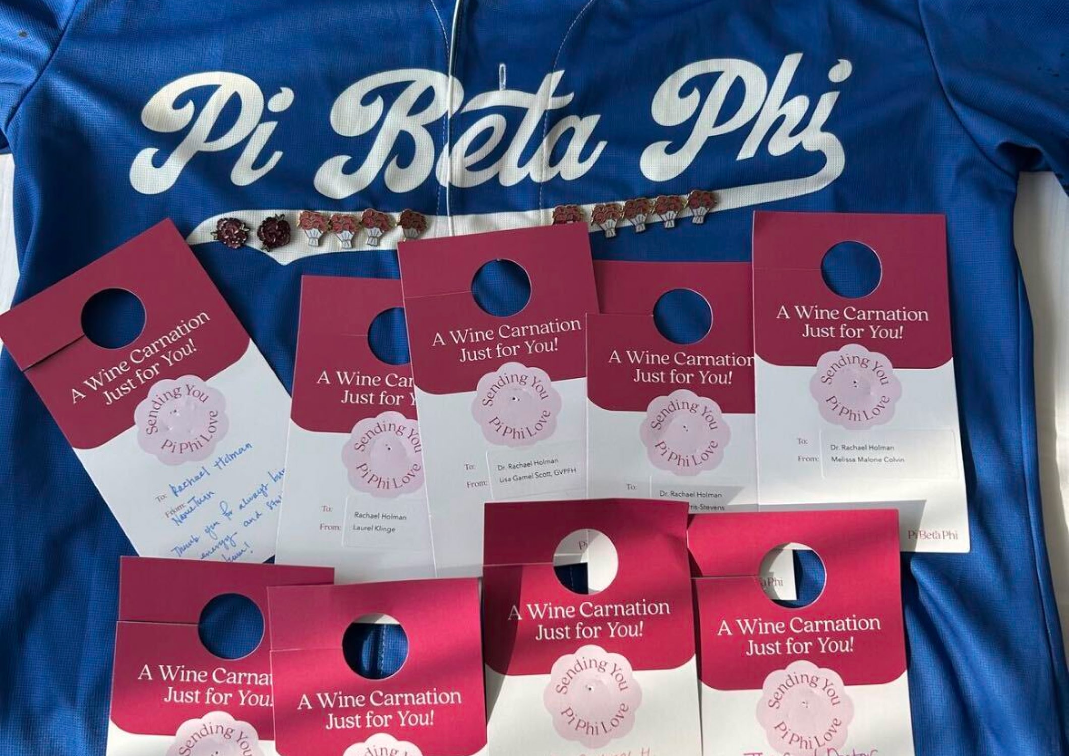 Branded sorority merchandise featuring a graphic T-shirt and coordinating enamel pins.